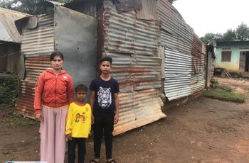 Mẹ con chị Ner bên căn nhà bị tốc mái sau cơn mưa bão, ngay sau đó Chị đã được Hội giúp xây nhà
